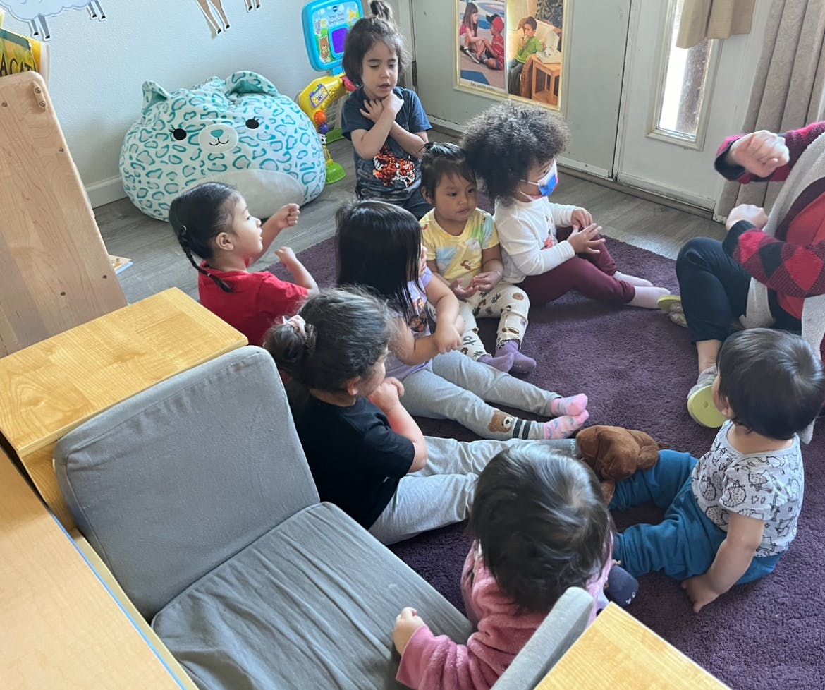 Group of children sitting on a rug in a classroom