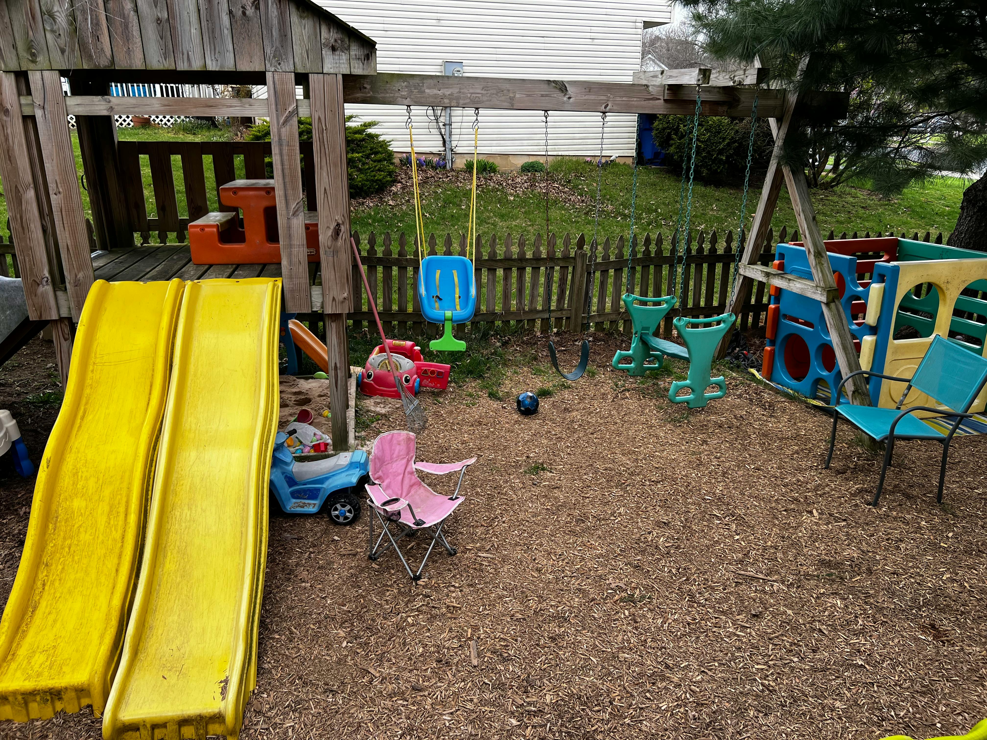 Outdoor playground with yellow slides, swings, and various toys