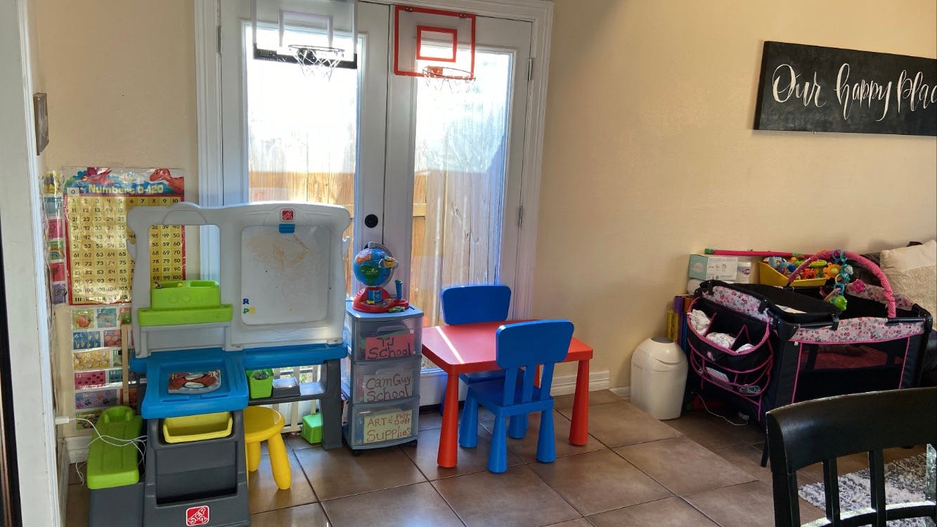 Playroom with children's table and chairs, toys, and a play kitchen
