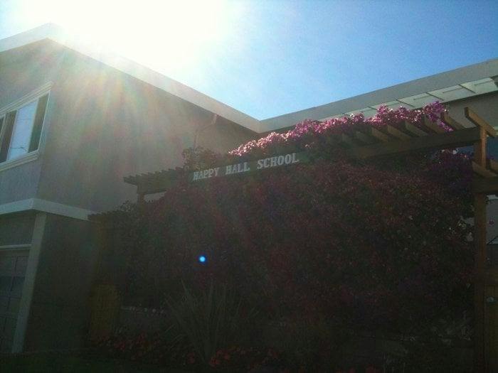 Building exterior with "HOYT HILL SCHOOL" sign and flowering vines