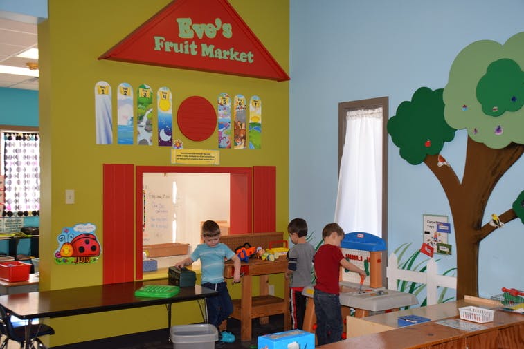 Children playing in a fruit market play area