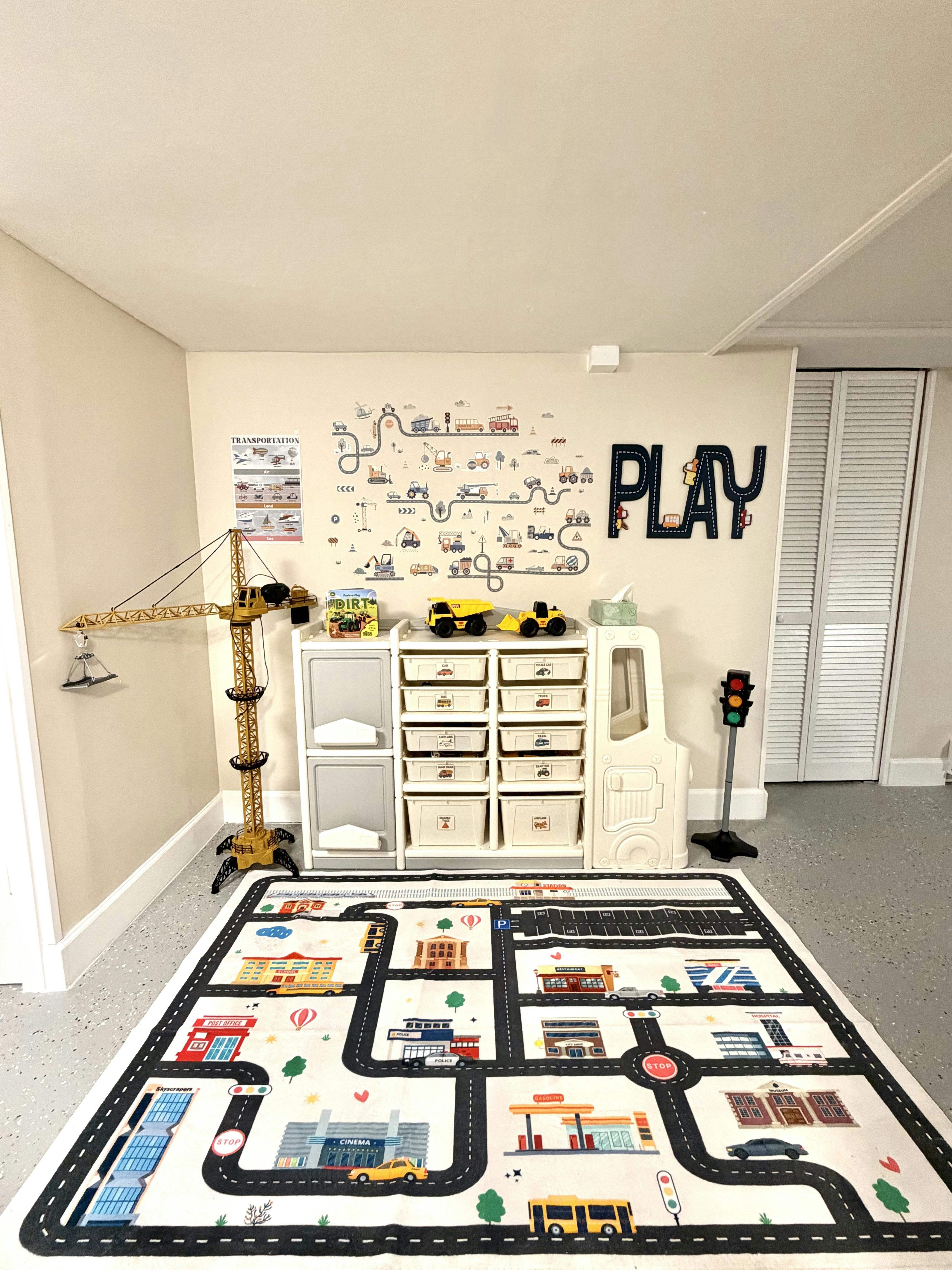 Playroom with a city-themed rug, toy crane, and storage unit