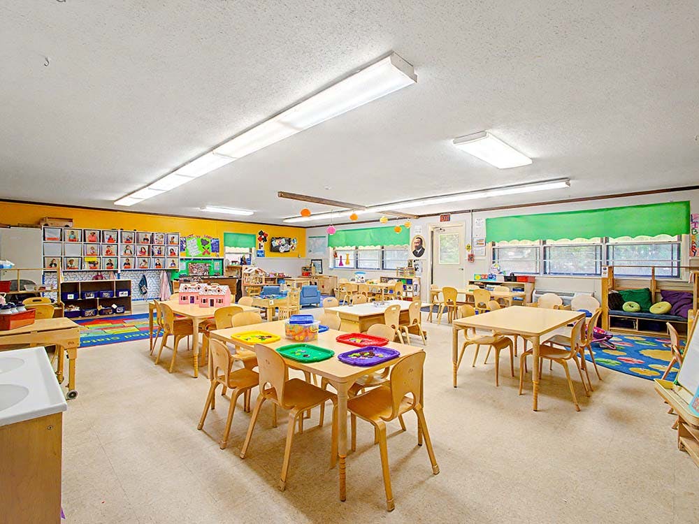 Empty classroom with small tables and chairs