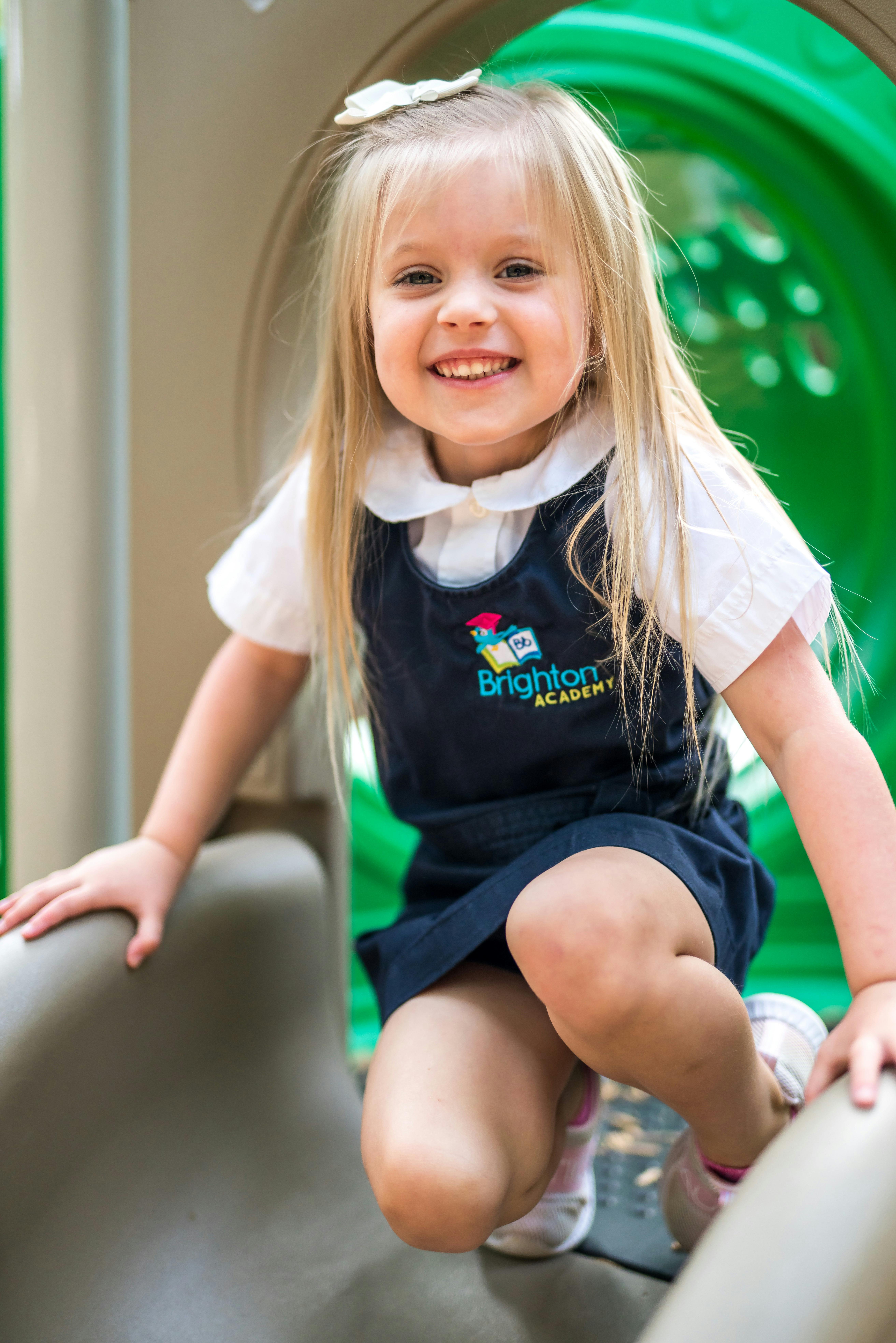 Child in uniform on a playground slide