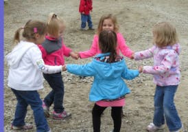 Five children holding hands in a circle