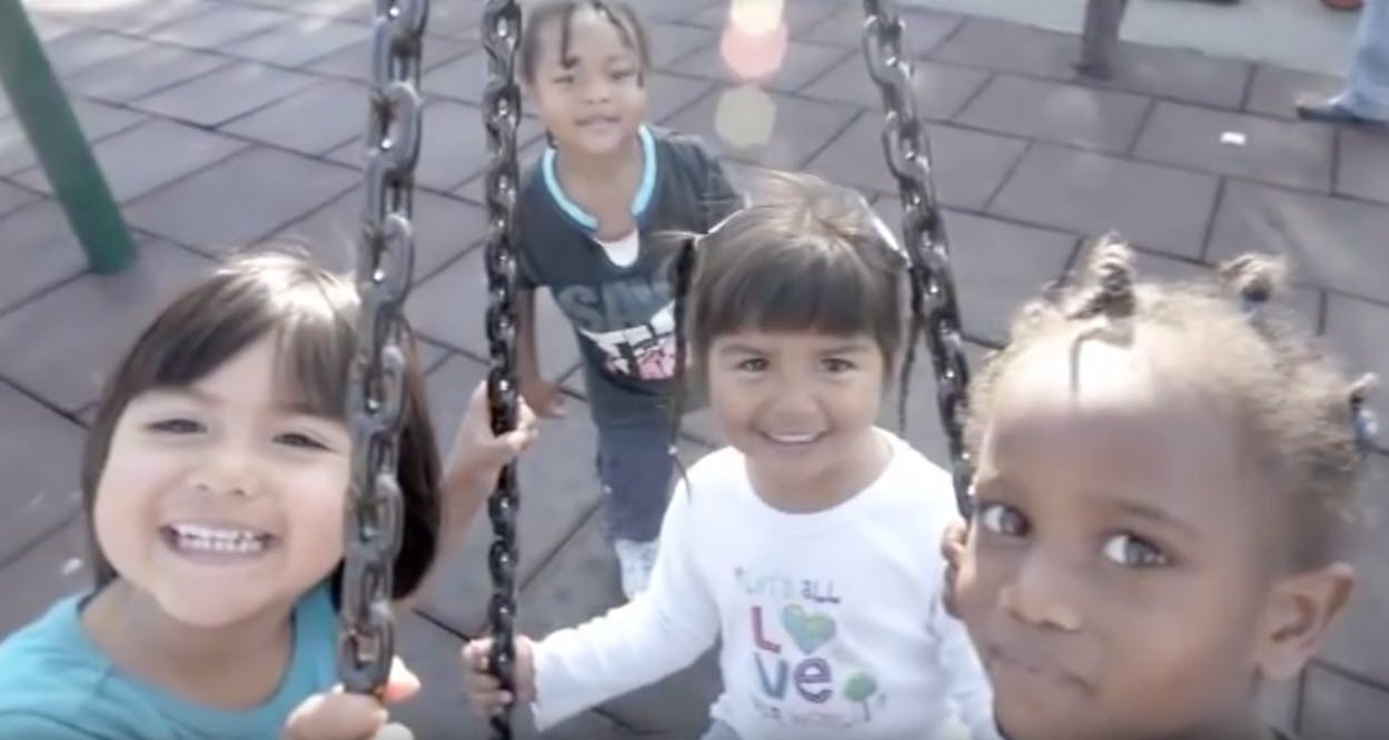 Four children on a playground swing set