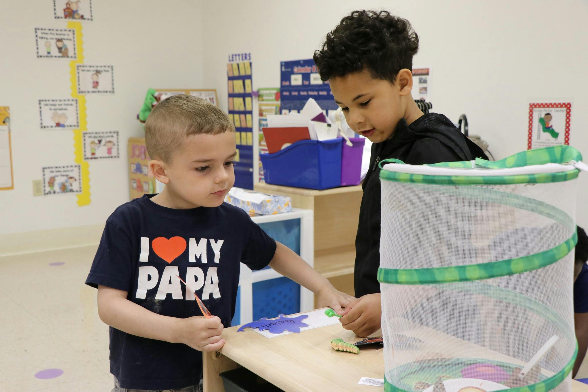 Two children working on a craft project at a table