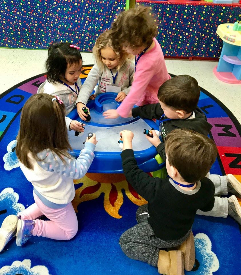 Children playing with a water table in a classroom