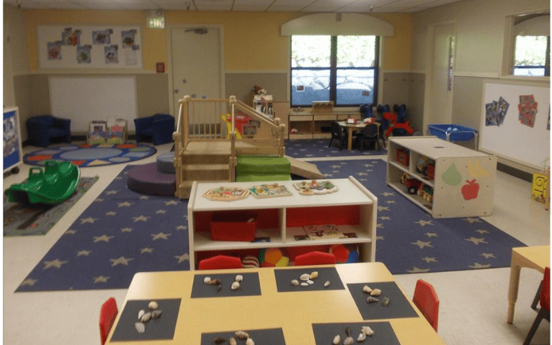 Classroom with play furniture, tables, and a star-patterned rug