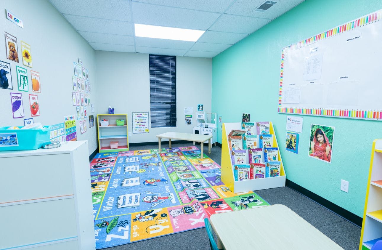 Colorful early childhood learning room with alphabet rug and bookshelf