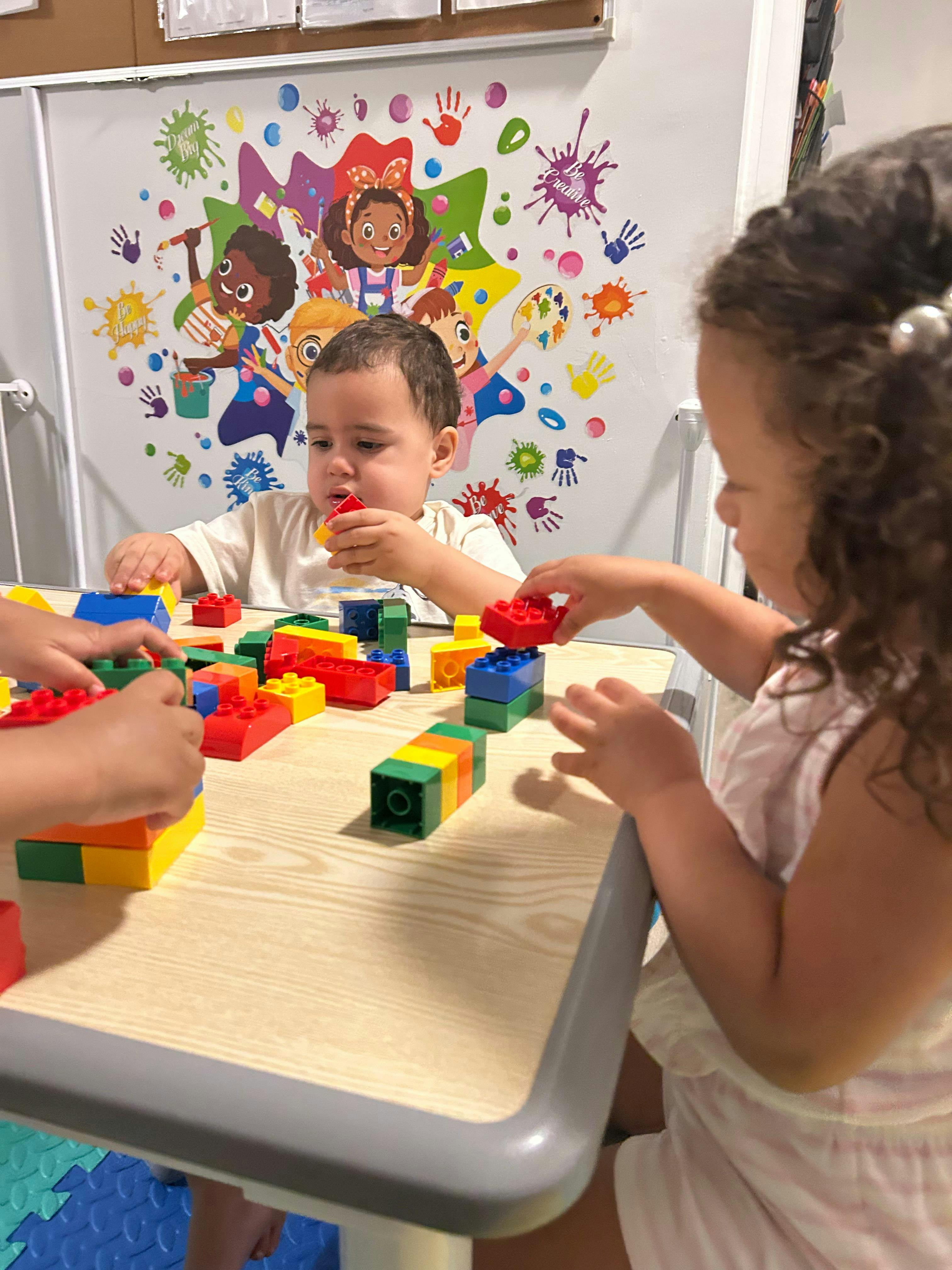 Children building with colorful plastic blocks at a table