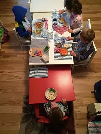 Children sitting at tables with food