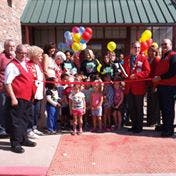 People and children at a ribbon cutting ceremony