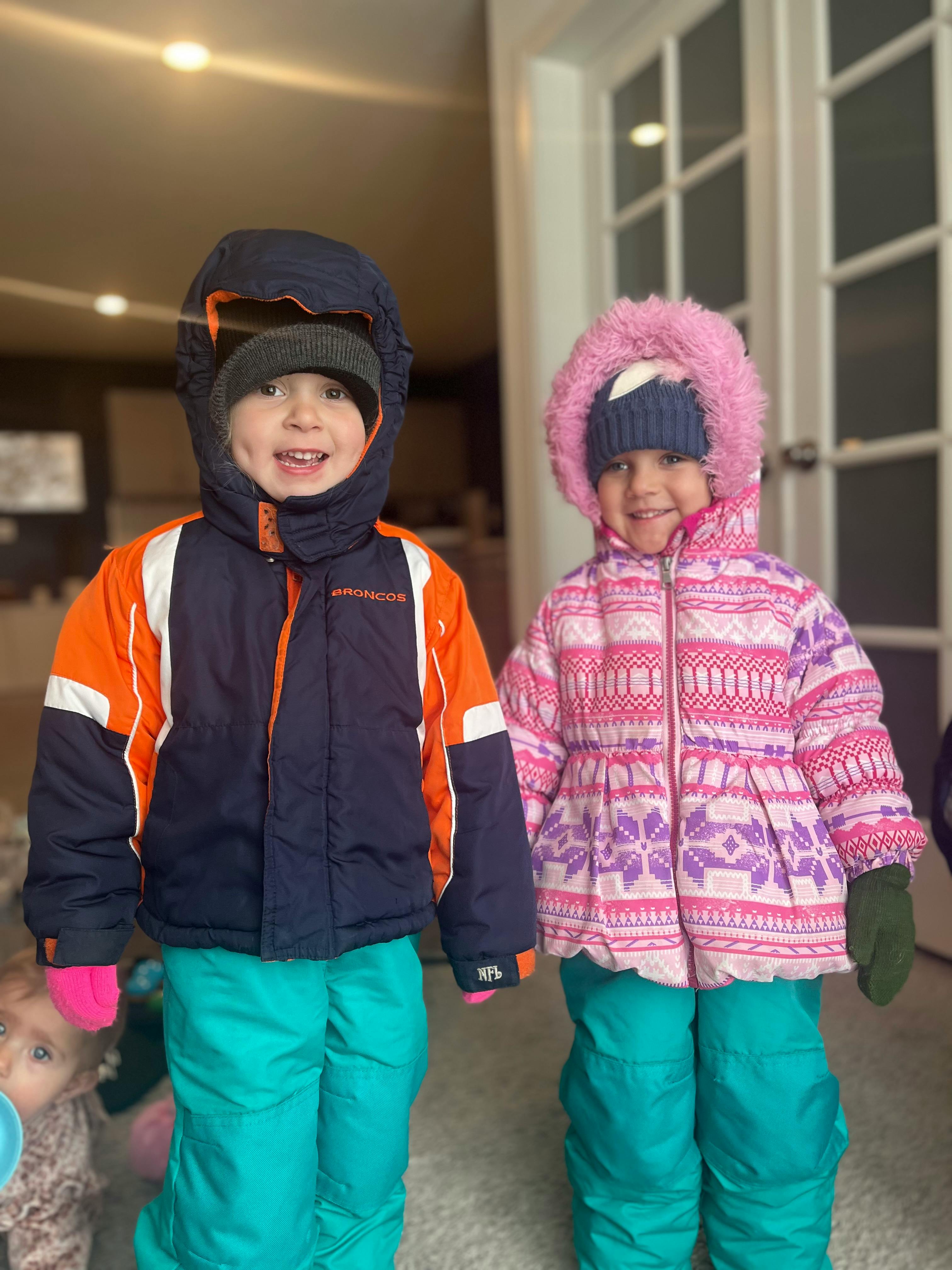 Two children in winter coats and snow pants