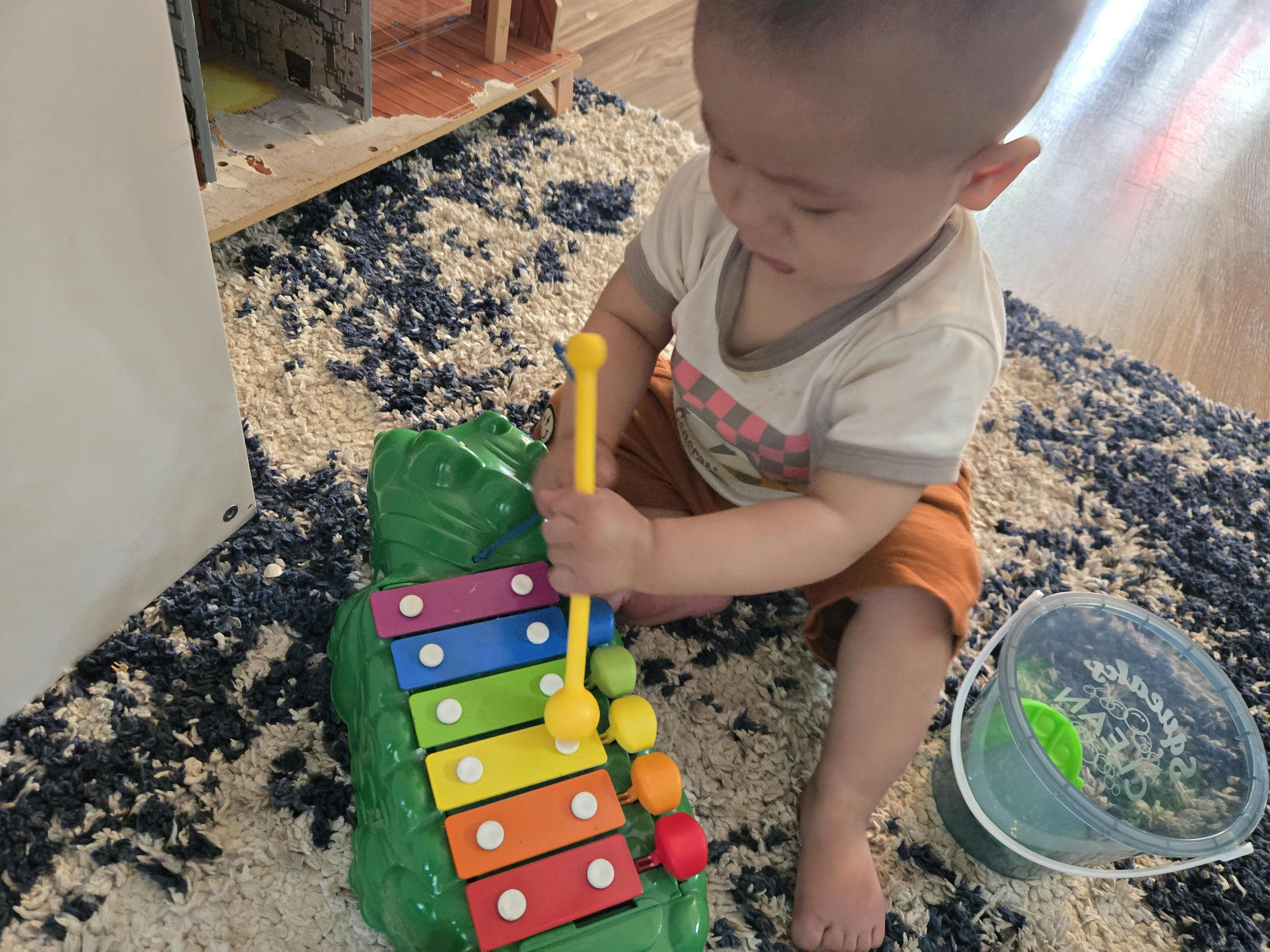 Child playing with a colorful toy xylophone