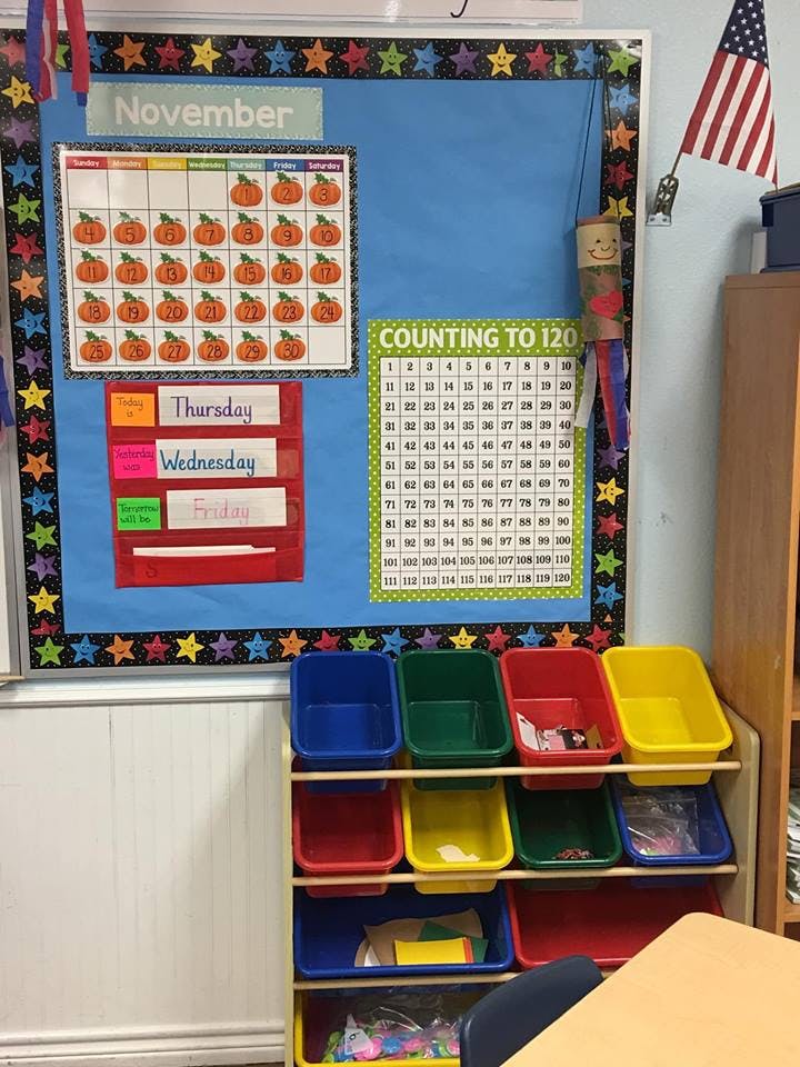 Classroom bulletin board with November calendar and counting chart above storage bins