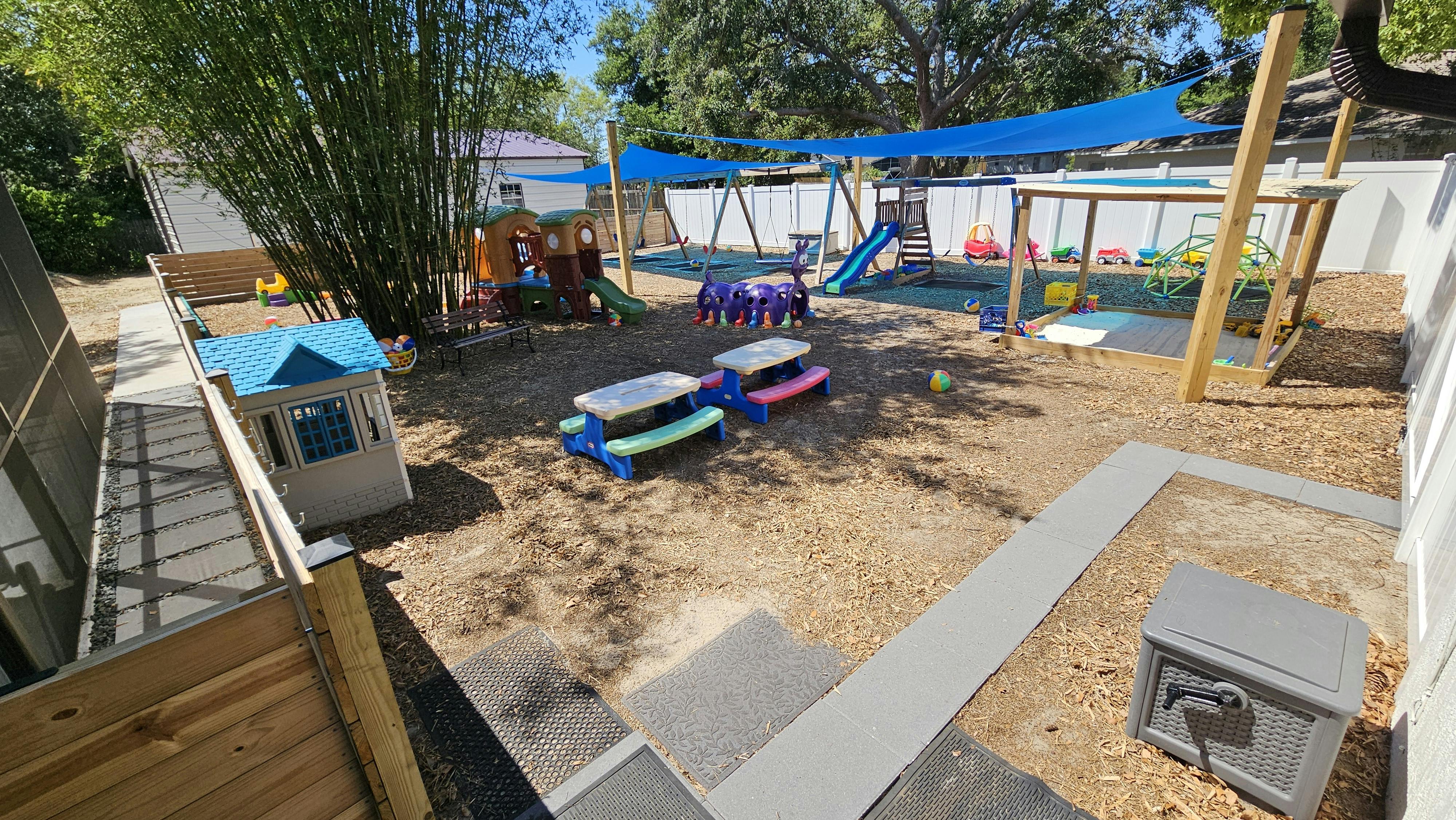 Outdoor playground with play structures, swings, and picnic tables