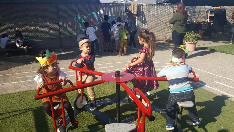Children playing on a red merry-go-round