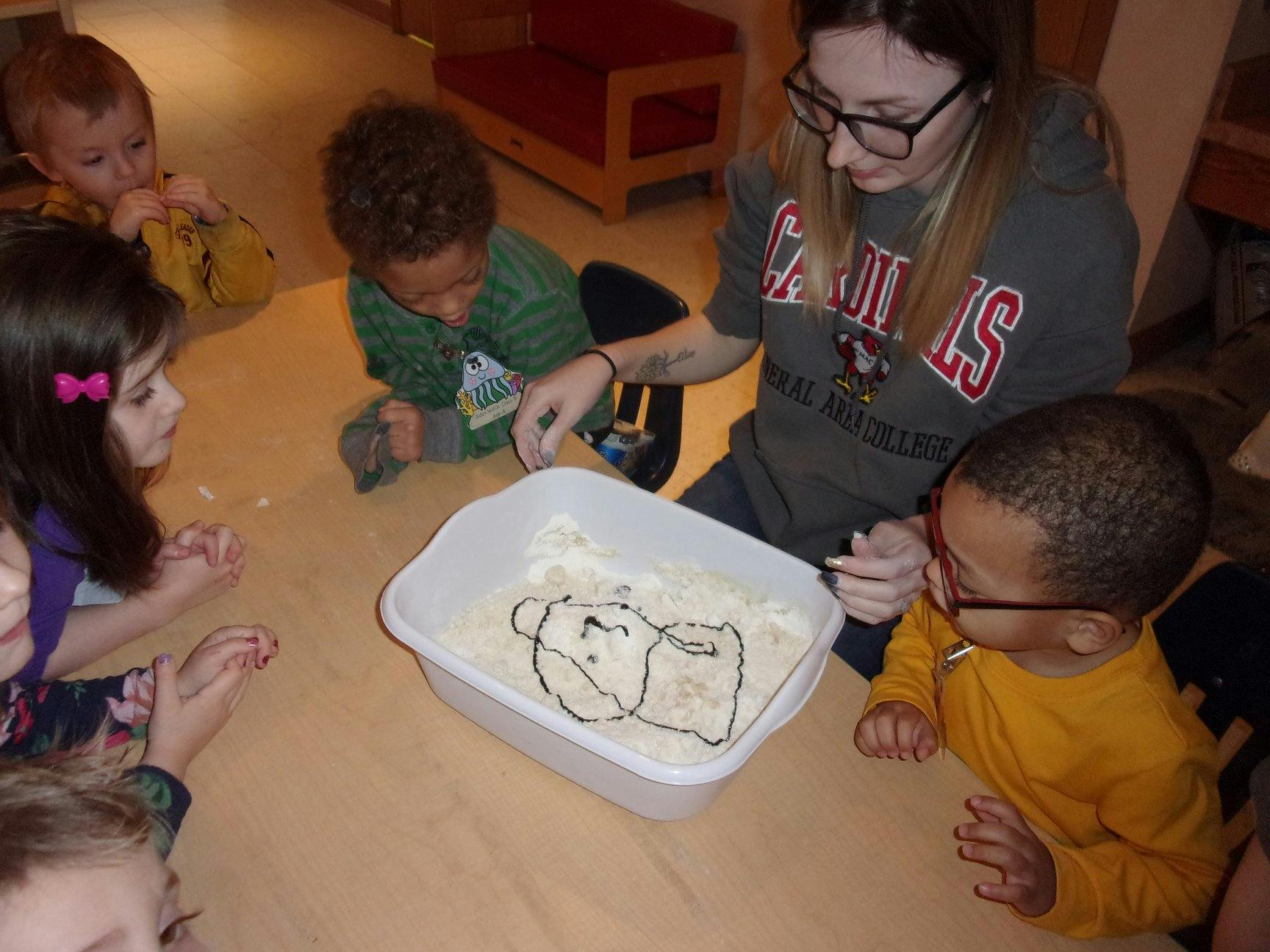 Person and children mixing ingredients in a bowl