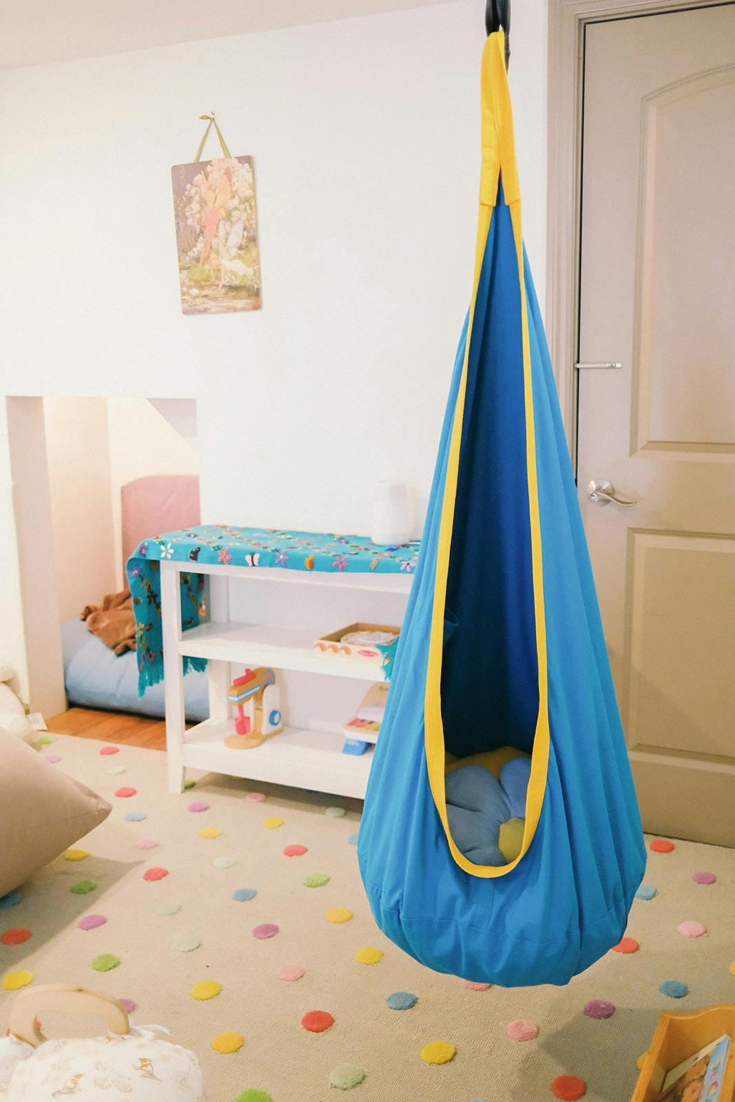 Fabric pod swing hanging in a play room