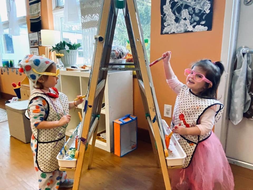 Two children painting at an easel