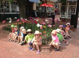 Children sitting around a flower bed