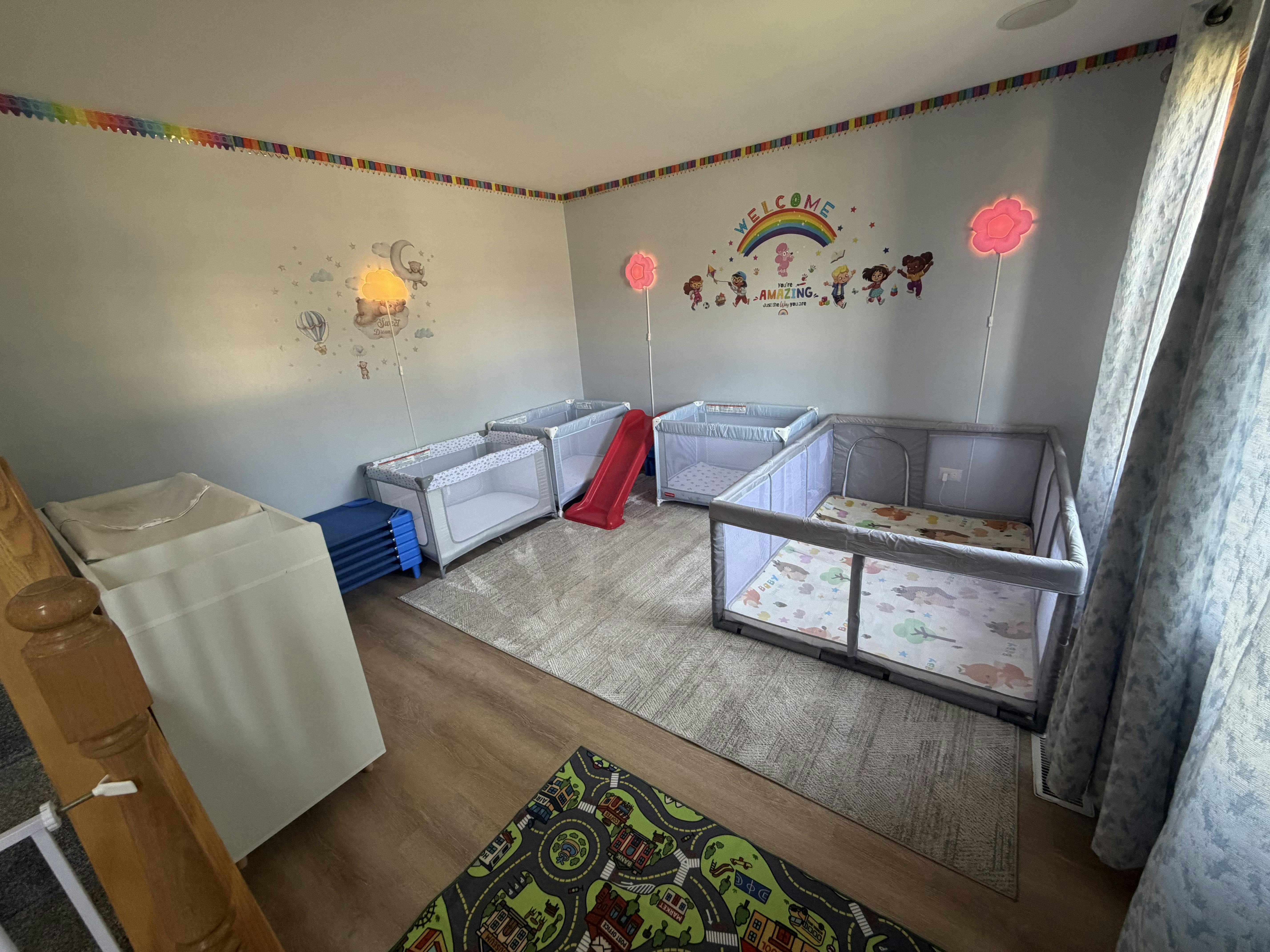 Childcare room with playpens and a play rug