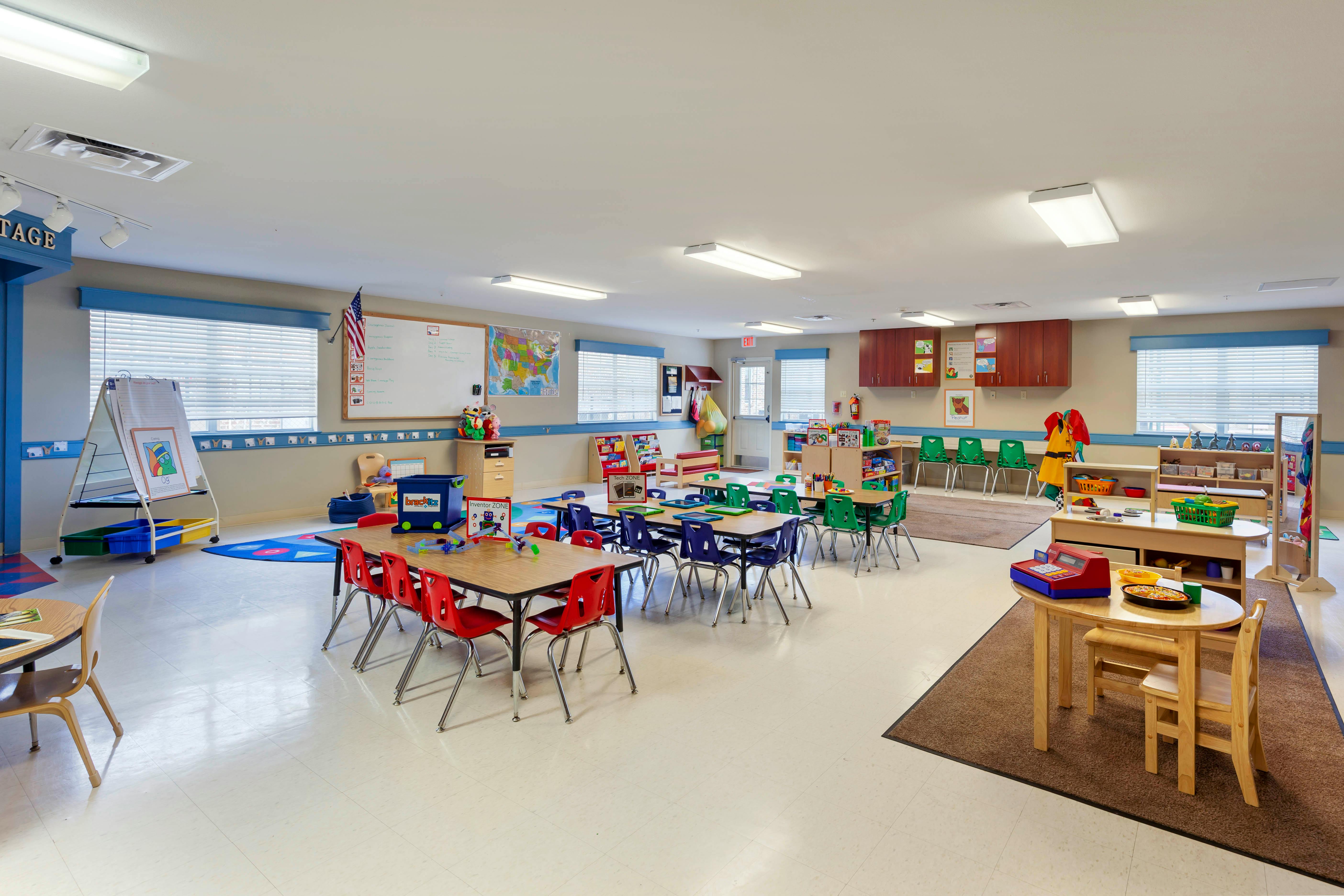 A colorful empty classroom with small tables and chairs