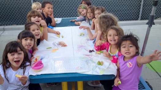 Children sitting around a table with art supplies