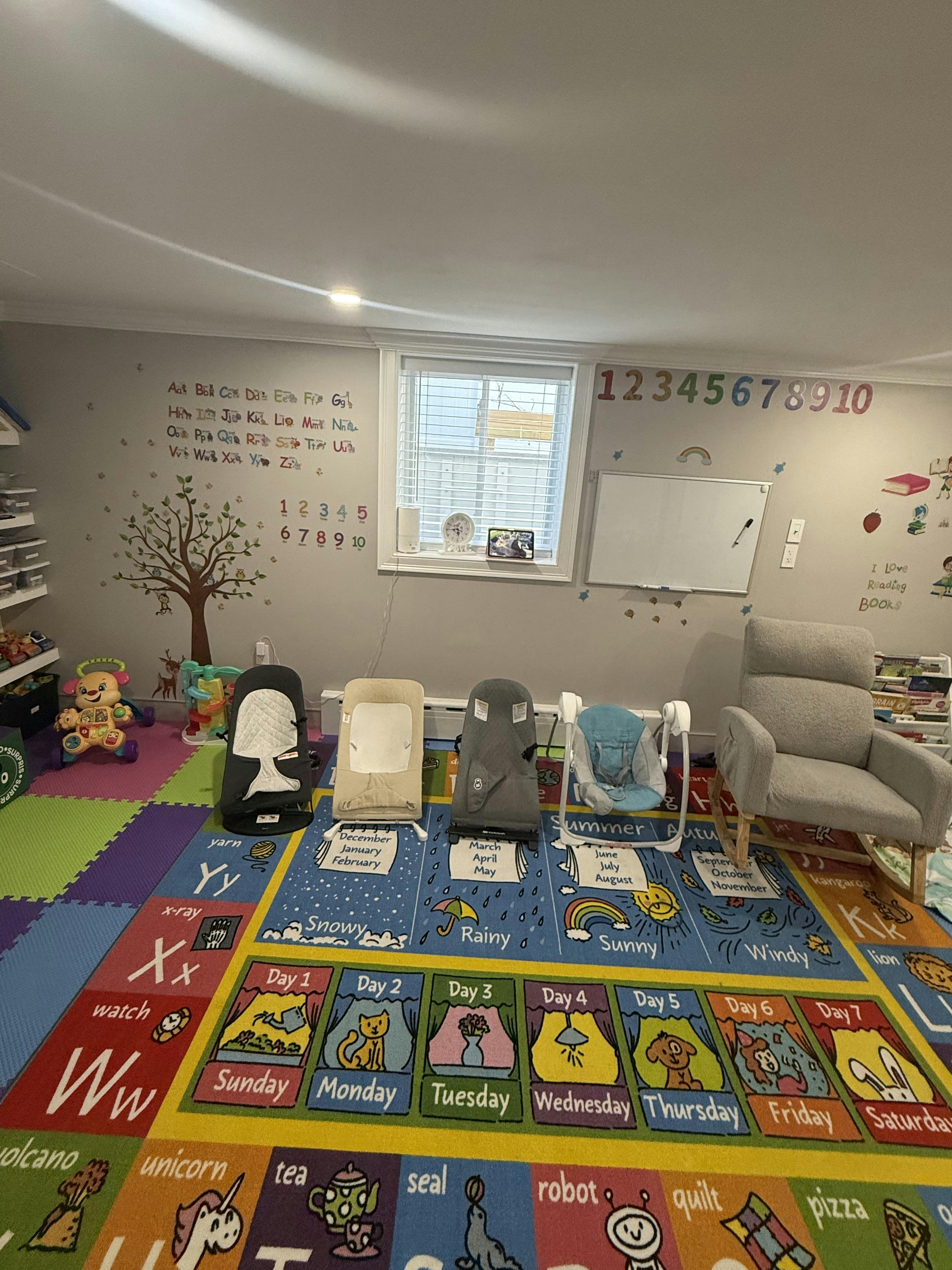 Playroom with alphabet and number wall decals, play mats, and baby gear