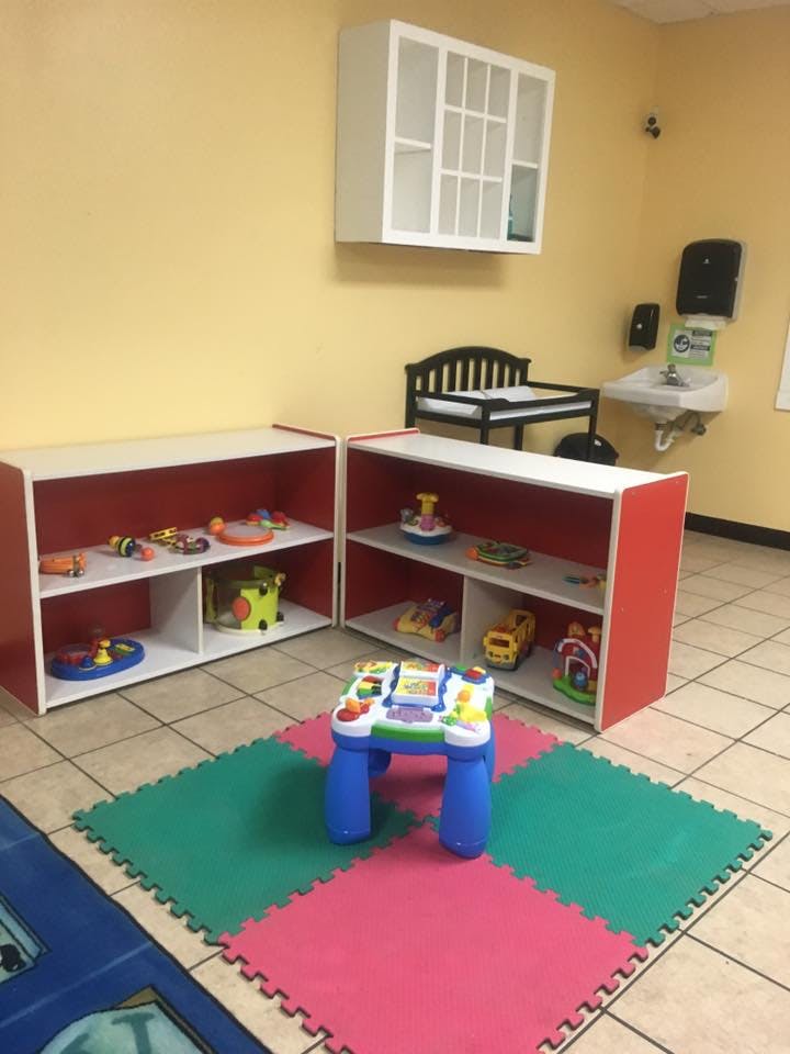 Playroom with shelves of toys, a changing table, and a small activity table