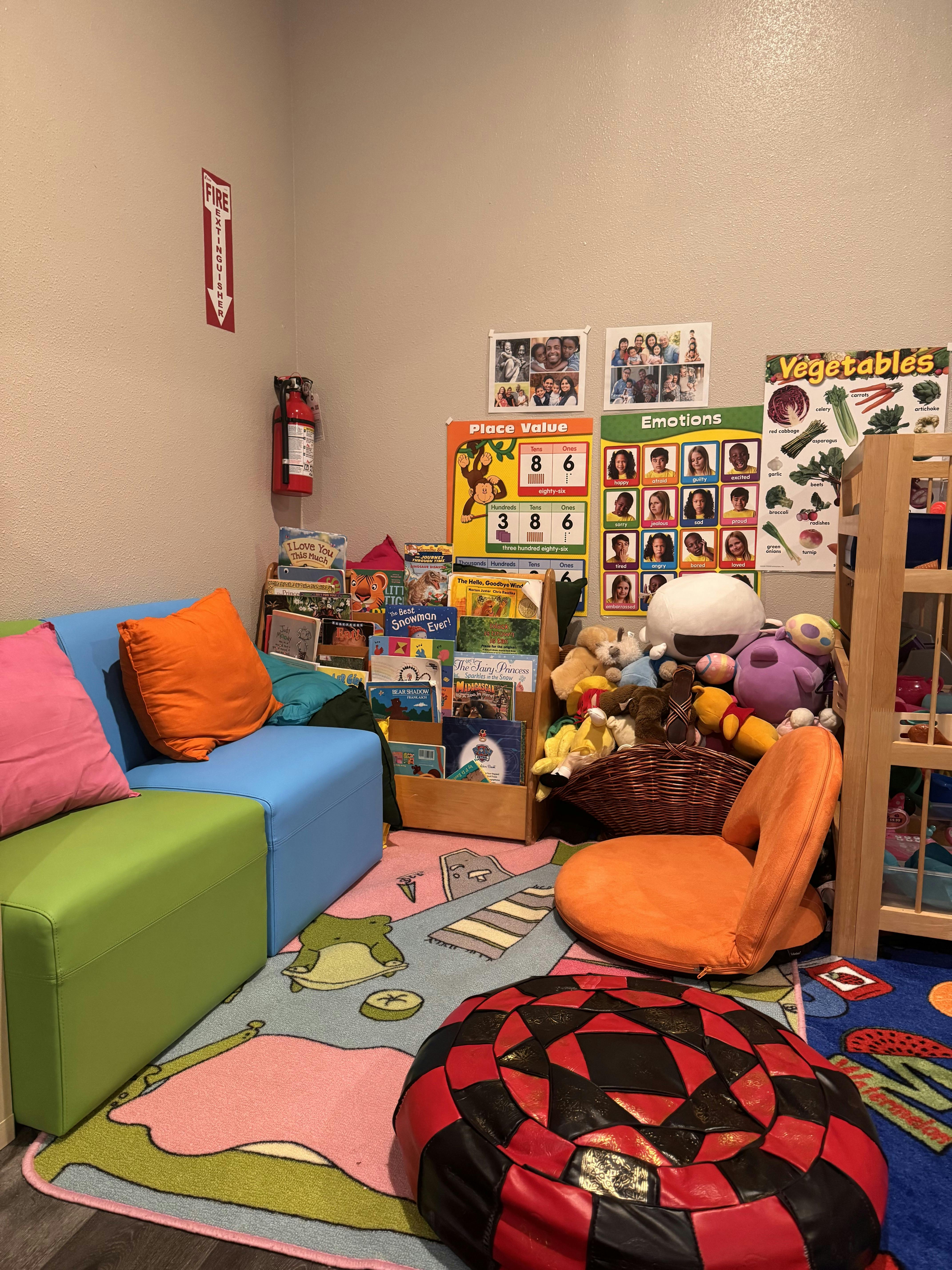 Children's play area with colorful seating, books, and educational posters