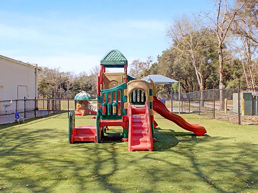Playground with slides and climbing structure on artificial turf