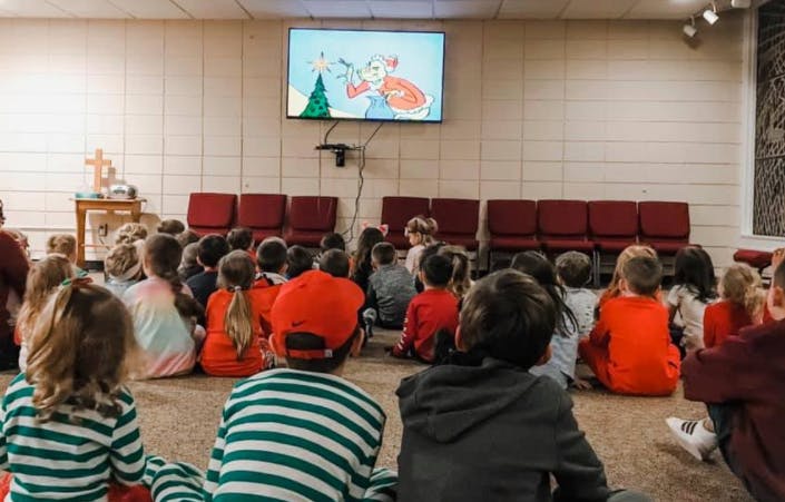 Children sitting on floor watching a screen