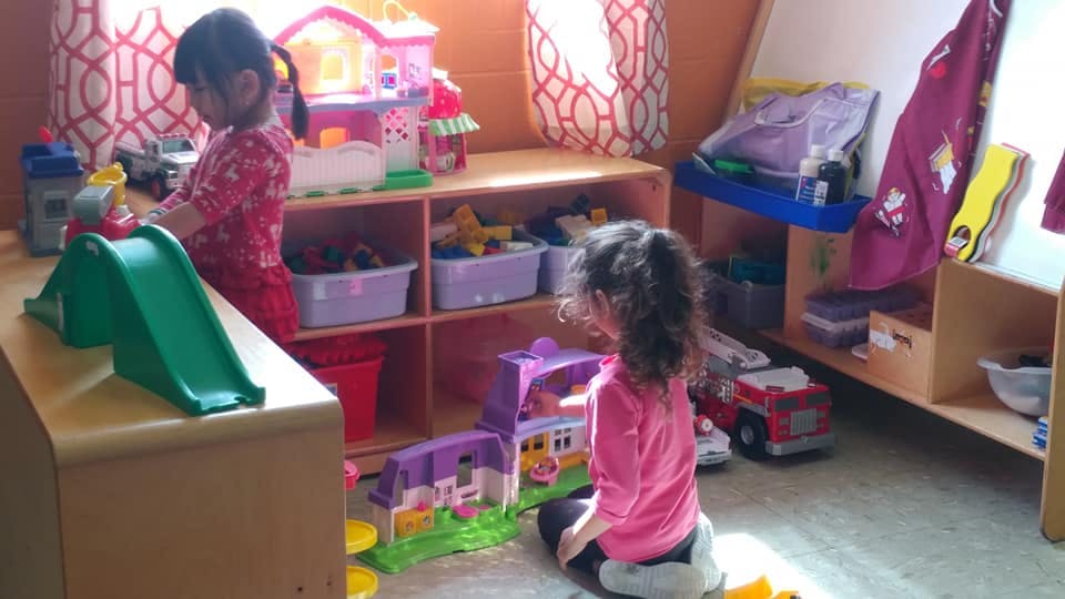 Two children playing with toys in a room