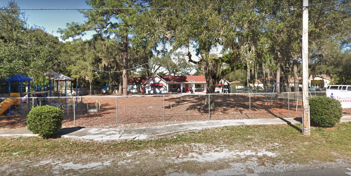 Playground with a chain-link fence in front of a building