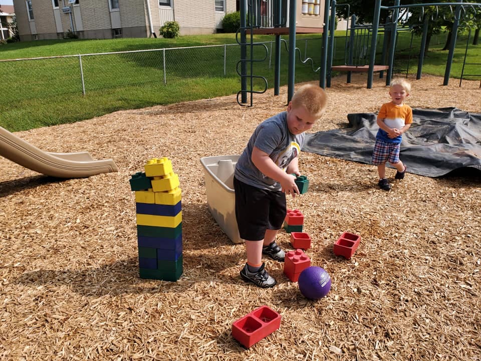 Child playing with large blocks on a playground