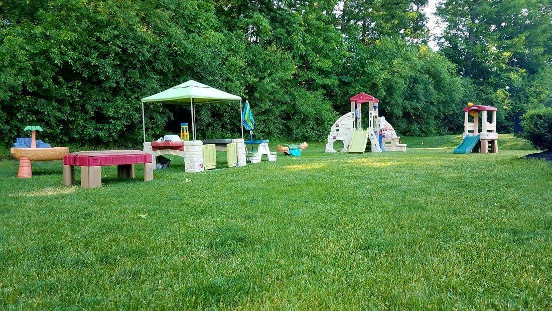 Playground with a green canopy, red table, and two play structures