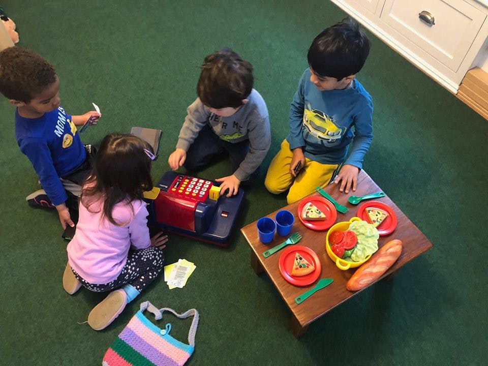 Children playing with toy cash register and play food