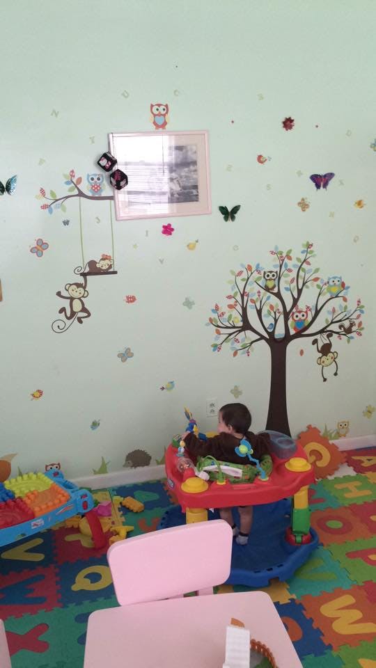 Child in a baby bouncer in a playroom