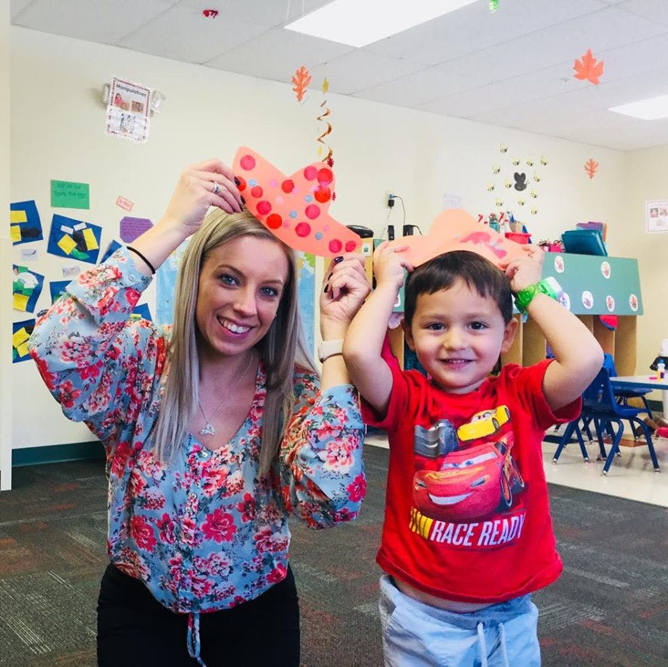 Person and child holding paper cutouts above their heads