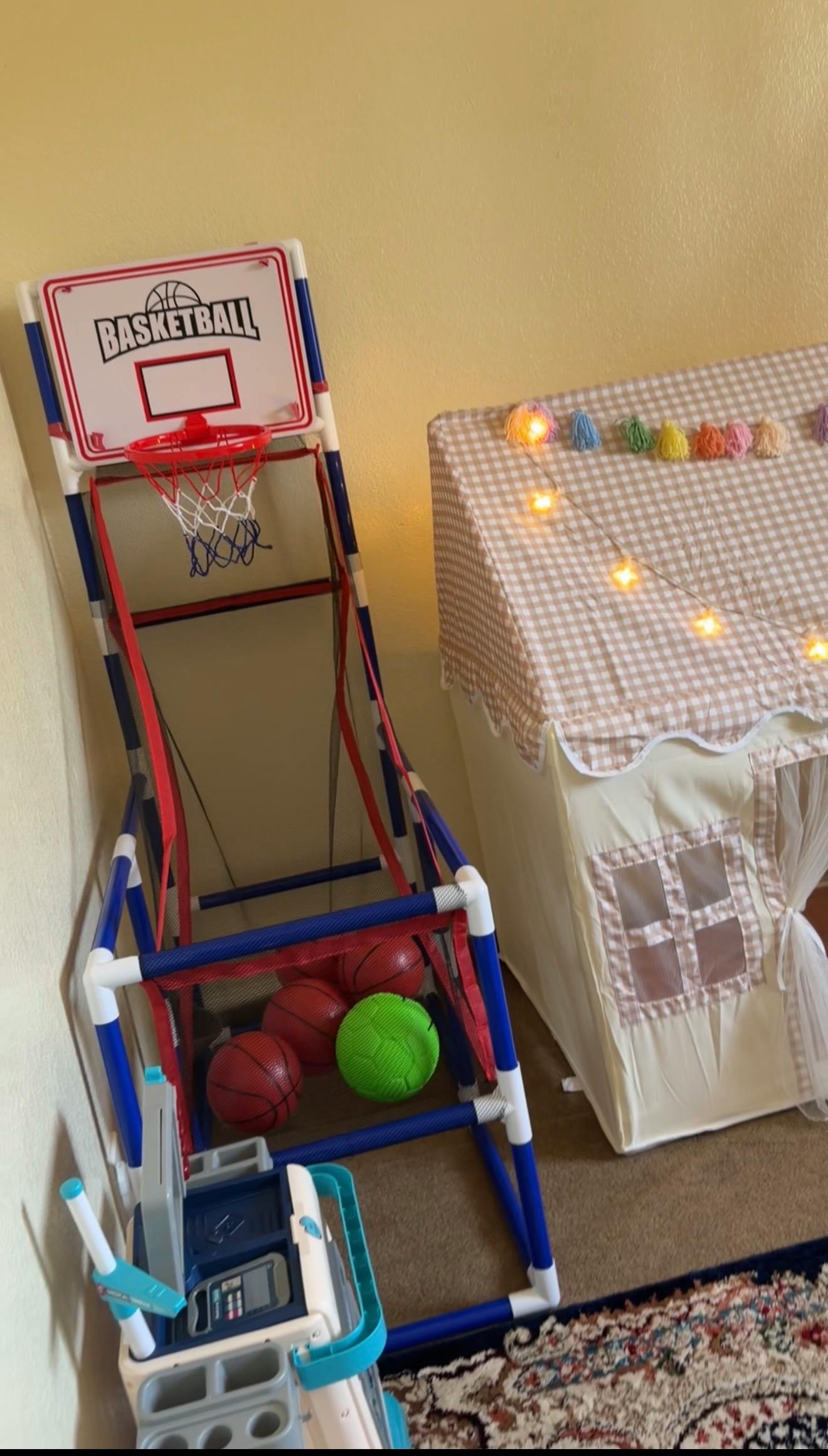 A toy basketball hoop setup next to a children's play tent