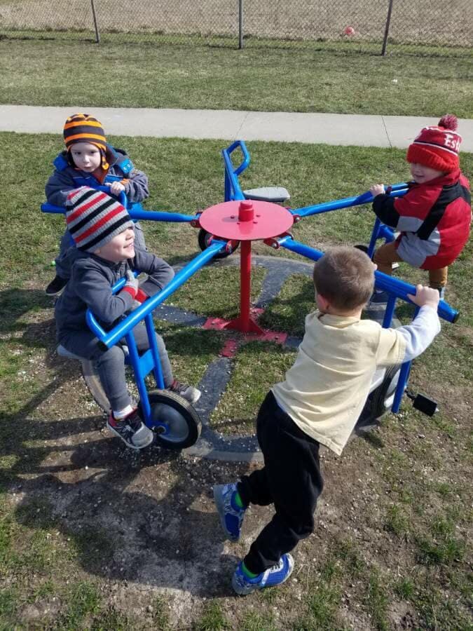 Children playing on a merry-go-round at a playground