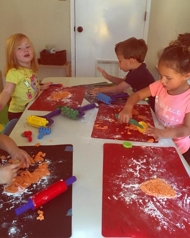 Children playing with dough and tools at a table
