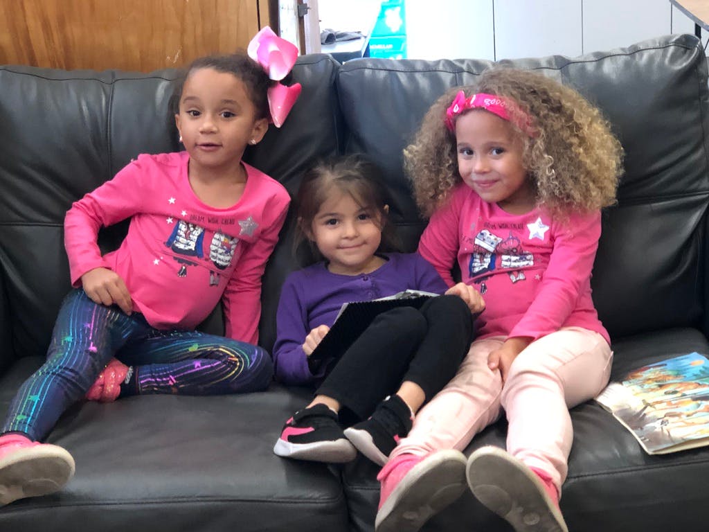Three children sitting on a couch