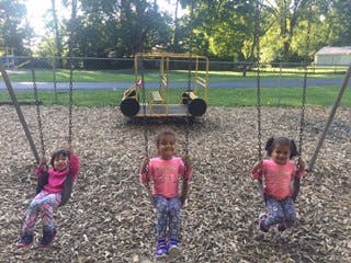 Three children on swings at a playground