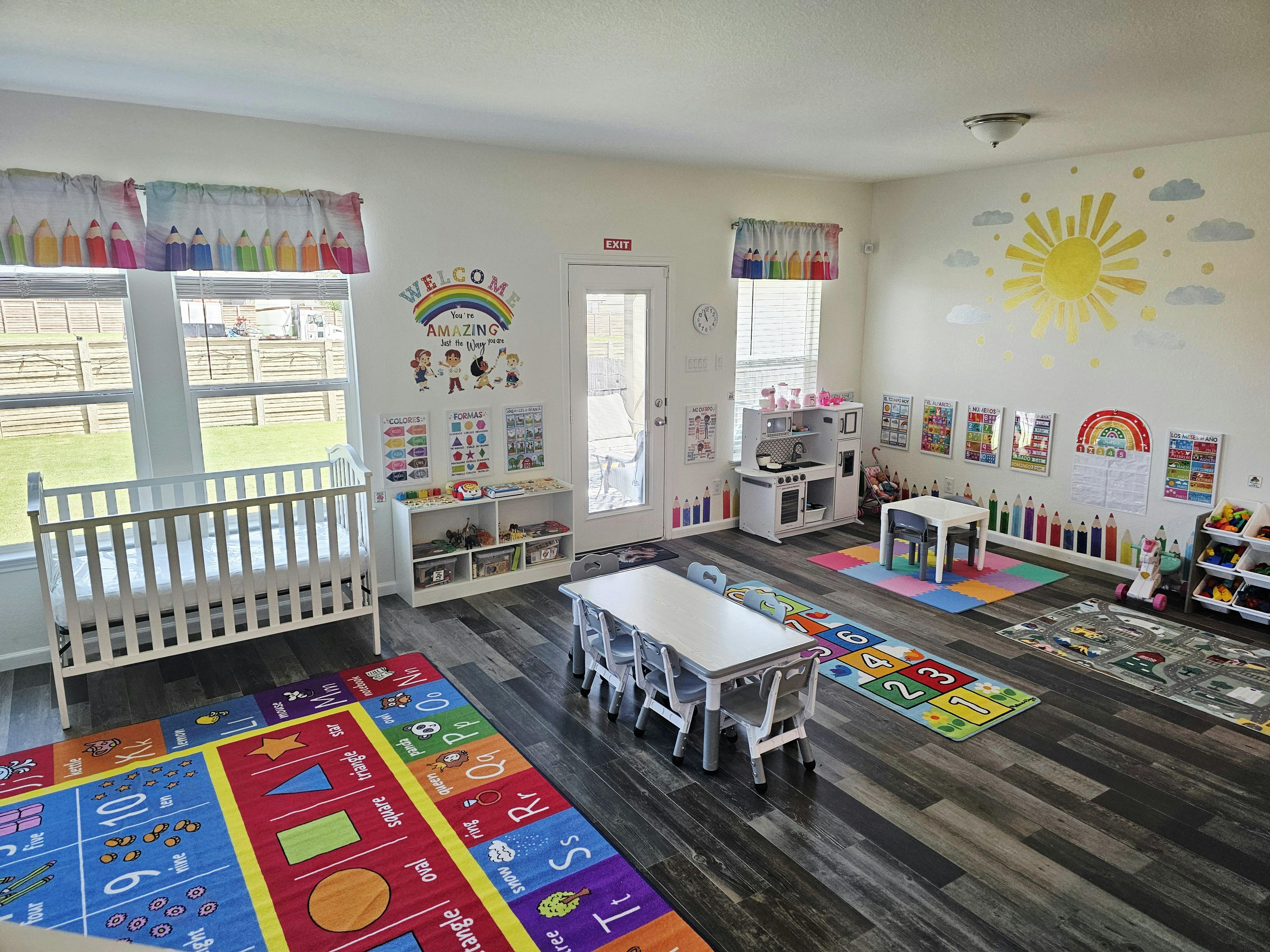 Playroom with crib, tables, and colorful rugs