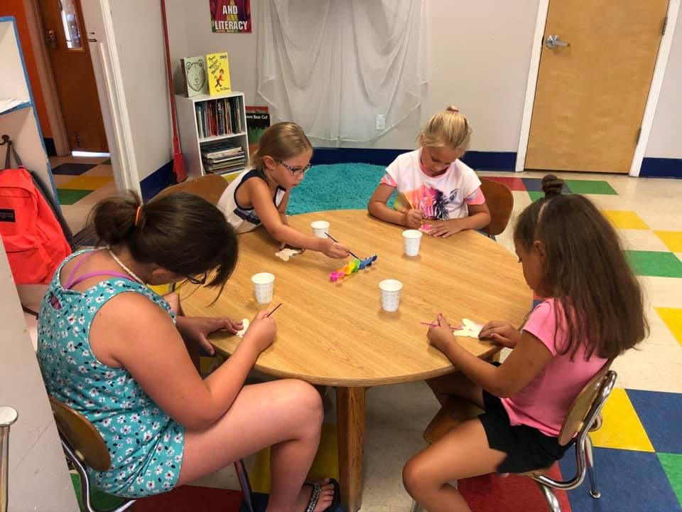 Four children sitting around a table doing an activity