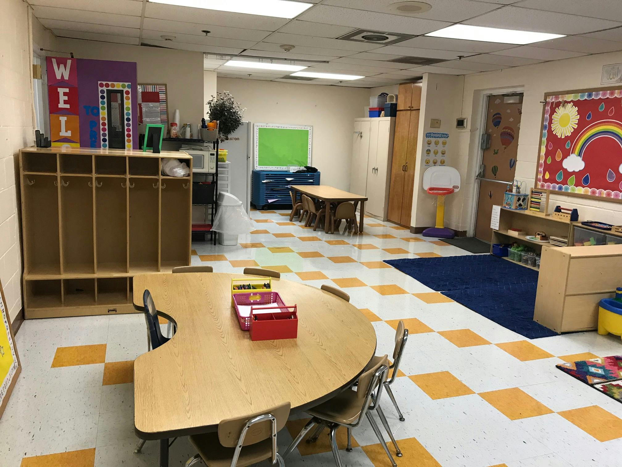 Classroom with tables, chairs, and storage cubbies