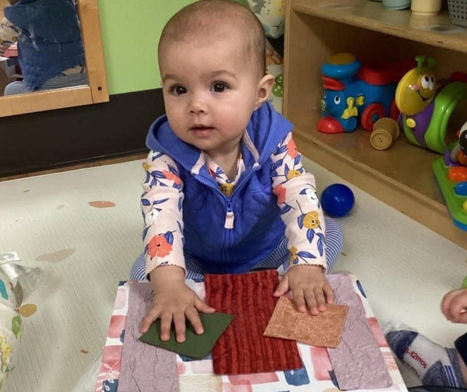 Child playing with fabric swatches